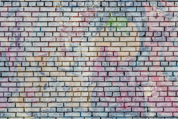 Beautiful horizontal texture of part of an old crashed brick colored wall in yellow red blue green brown hue on the photo