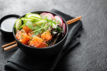 Salmon fish poke bowl with rice, radish,cucumber, tomato, sesame seeds and green onion. - obrazy, fototapety, plakaty