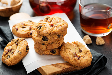 Cranberry cookies served with tea cup on wooden table. 