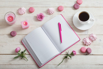notebook with cup of coffee on white wooden table