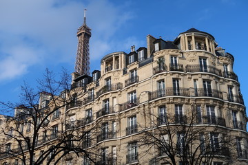 Fototapeta na wymiar Immobilier à Paris, façade d'immeuble haussmannien et vue sur le sommet de la tour Eiffel (France)