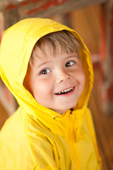 Adorable portrait of small boy in yellow raincoat 