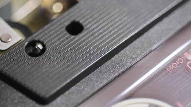 macro tracking footage of vintage cassette playing inside music player