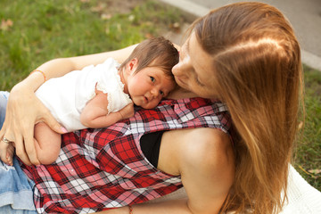 Mother holding her newborn baby girl on her body