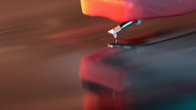 macro footage of vintage playing vinyl disk with focus on stylus and shallow depth of field
