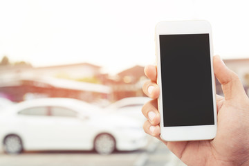 close up people man hand using a mobile smart phone call a car mechanic ask for help assistance because car broke in parking outdoor. standing wait beside broken car background. blank of empty screen.