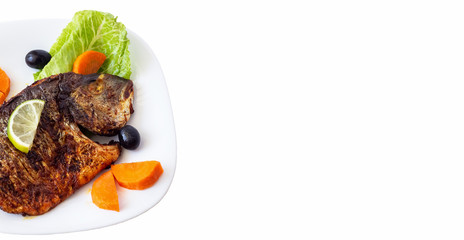 Grilled fish sea bream with vegetables on white plate. White background. Healthy diet food concept. Banner size.