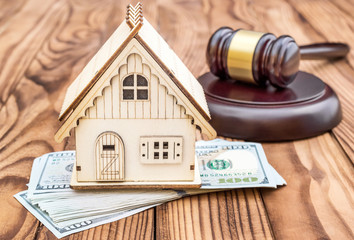 Model of house with gavel and money on the table. - obrazy, fototapety, plakaty