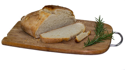close up of rustic white bread on a wooden board with rosenary