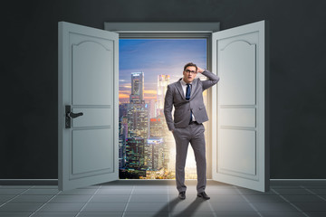 Fototapeta premium Puzzled businessman in front of big door