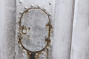 metal old plate weathered gray rivets door oval part of the boat hull close-up industrial background design base