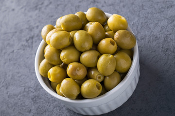 Green olives in a bowl. Closeup