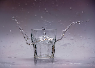 Naklejka na ściany i meble Glass of water with splash isolated on white background