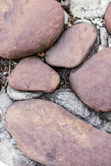 base of terracotta cobblestone stone close-up on background.cement gray hard substrate design website