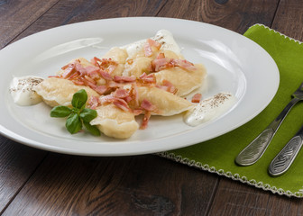 Cooked dumplings with cheese pork scratching and creme fraiche