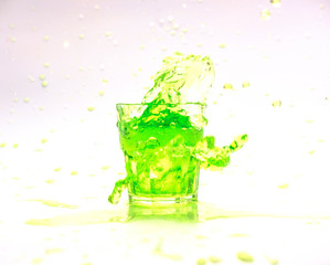 Green splash in glass isolated on white background