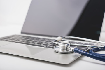 Health stethoscope on keyboard of laptop computer