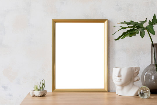 Modern and eclectic room interior with abstract wiped walls, gold mock up frame head sculpture, air plants, vase with leaf .Stylish space with design accessories. Stylish home decor. Real photo. 