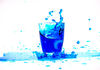 Blue water splash in glass isolated on white background