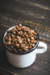 Metal cup full of coffee beans. Selective focus. Shallow depth of field.