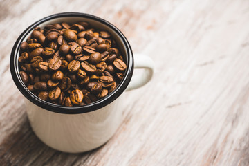 Metal cup full of coffee beans. Selective focus. Shallow depth of field.