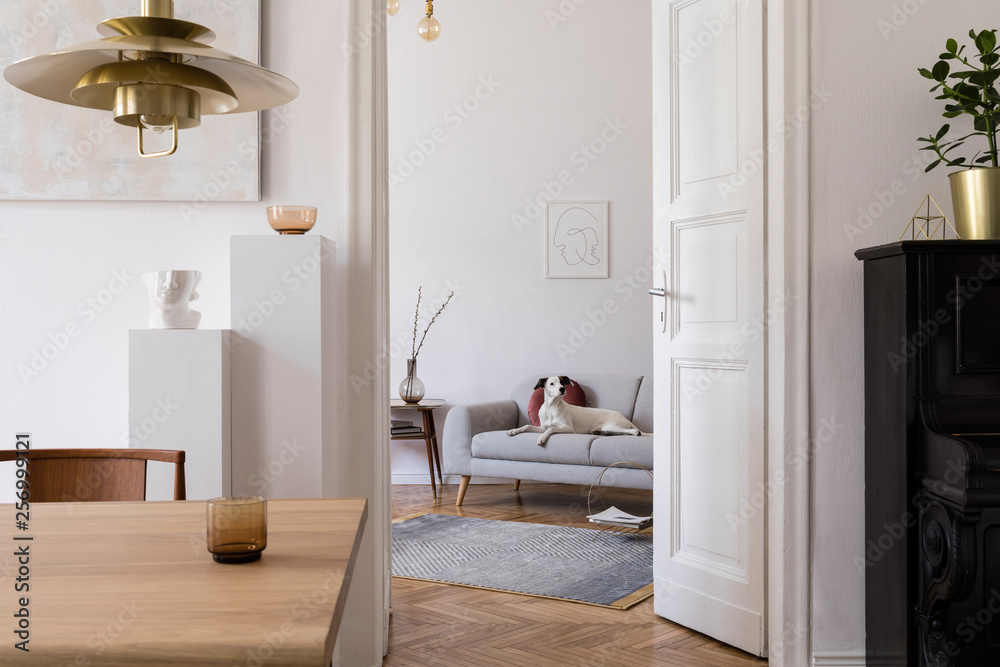 Wall mural stylish scandi interior of home space with design wooden table, chairs, sofa and gold pendant lamp. 