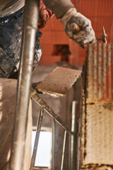Real construction worker making a wall inside the new house.