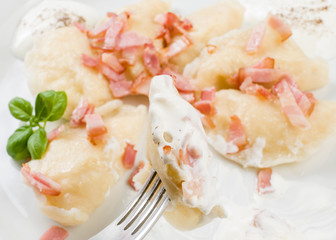 Cooked dumplings with cheese pork scratching and creme fraiche