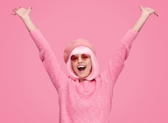 Excited woman in beret raising hands