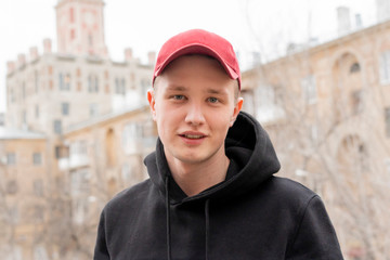 young hamdsome man in cap and hoodie in the city streets