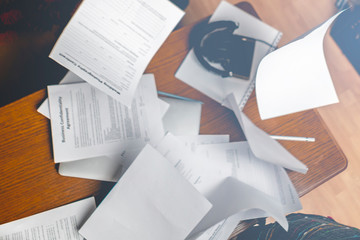 flying documents or in the air in the office above the wooden table