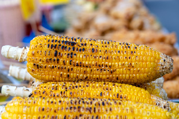 Grilled yellow corn for sale on street food market in Thailand , closeup