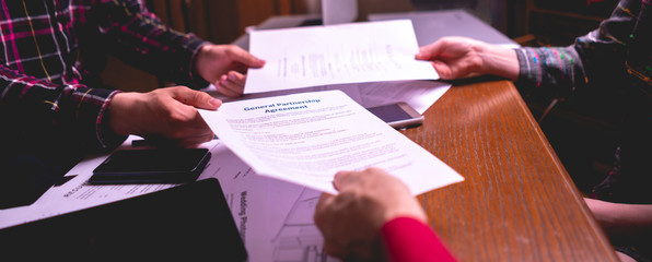 two colleagues pass documents in the office