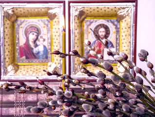 Obraz premium branches with willow fluffy flowers on the background of Christian icons