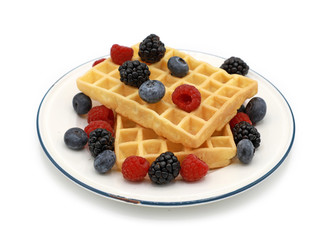 fresh homemade waffles with wild berries on a plate isolated  on white background