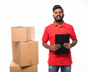 Delivery service, mail, people, logistics and shipping concept - happy indian man with parcel boxes and clipboard isolated on white background