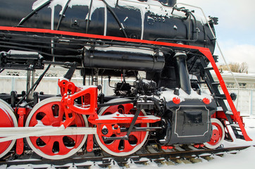 Old vintage Soviet red-black locomotive and its wheelbase