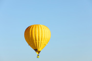 Beautiful view of gold hot air balloon in blue sky. Space for text