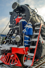 Old vintage Soviet black and red steam locomotive with a star