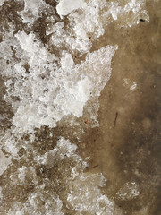 Texture of melting snow on the sidewalk closeup in Russia in early spring