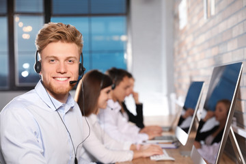 Technical support operator with colleagues in modern office