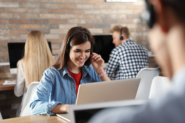 Technical support operator with colleagues in modern office