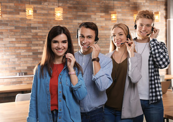 Technical support operators with headsets in modern office