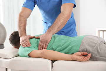 Doctor working with patient in hospital. Rehabilitation massage - obrazy, fototapety, plakaty