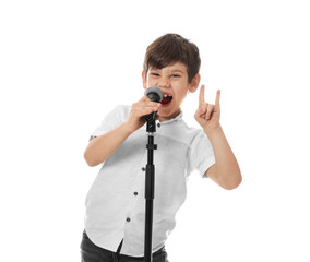 Cute little boy singing into microphone on white background