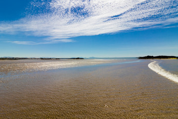 Summer coastal vista from Rhosneigr West Beach looking south-eastwards back to Rhosneigr & the Snowdonia Mountain Range, Anglesey, North Wales