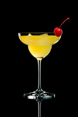  Orange cocktail with cherry on a black background