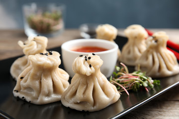 Plate with tasty baozi dumplings, sprouts and sauce on table, closeup
