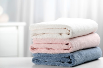 Stack of fresh soft towels on table