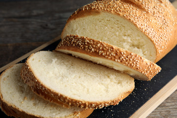 Tasty wheat bread on wooden board, closeup